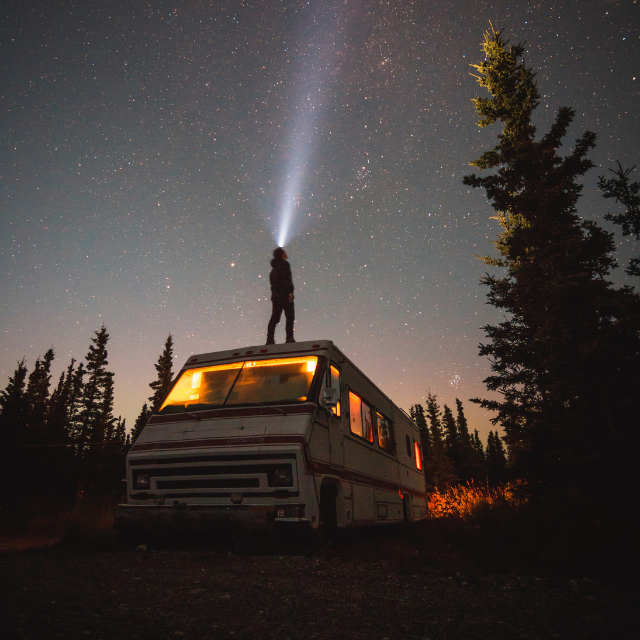 Man on top of camper at night